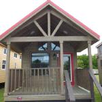 The Coyote P-561SL by Platinum Cottages and RRC Athens. this display model cabin features a front porch, large loft, stained exterior, and Blue Ponderosa pine accents throughout