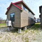 The Coyote P-561SL by Platinum Cottages and RRC Athens. this display model cabin features a front porch, large loft, stained exterior, and Blue Ponderosa pine accents throughout