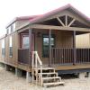 The Platinum Cottages P-645 HUD single section home with an optional front porch, clerestory windows and finished in stained Hardi siding.