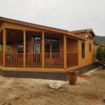 Bronze metal skirting to match roof. House is Mahogany stained Hardi